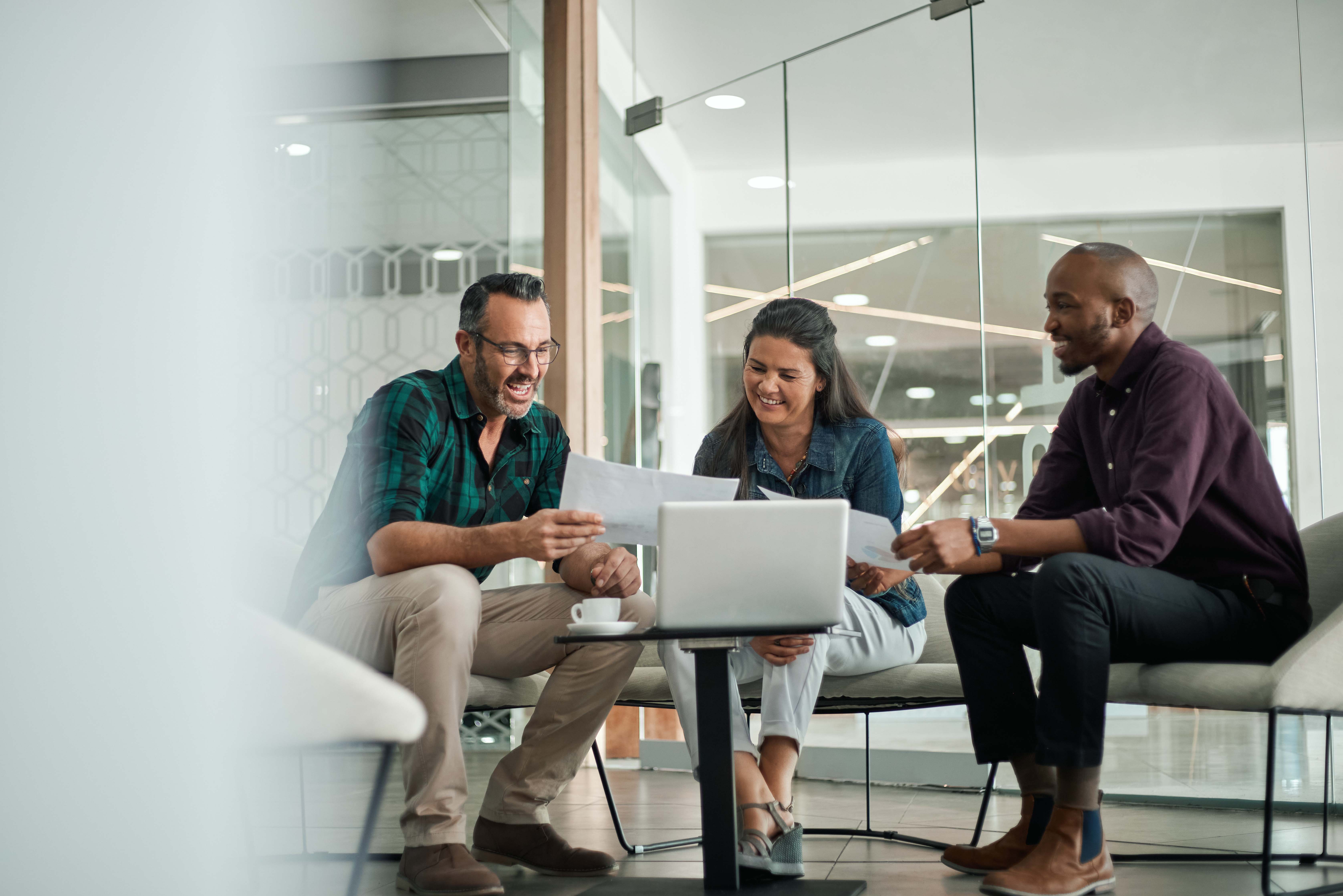 People meeting around a laptop to showcase information to one another